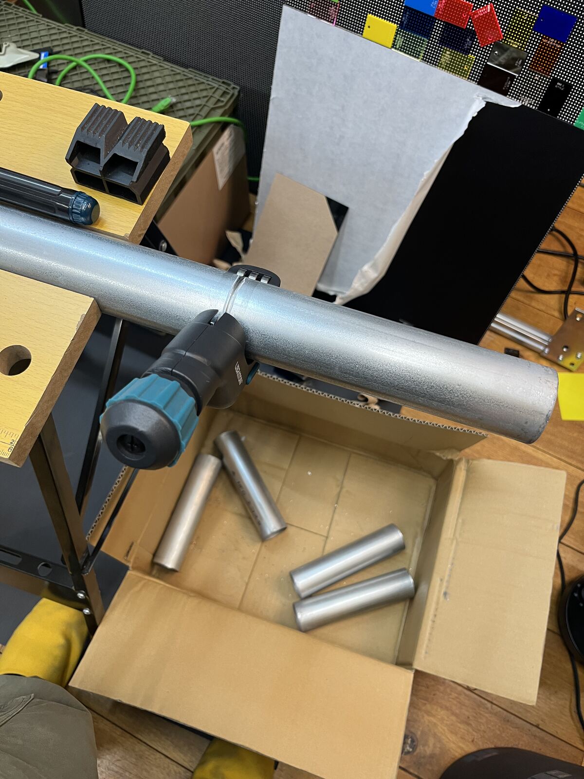 作業台に固定した単管パイプに、パイプカッターを取り付ける。