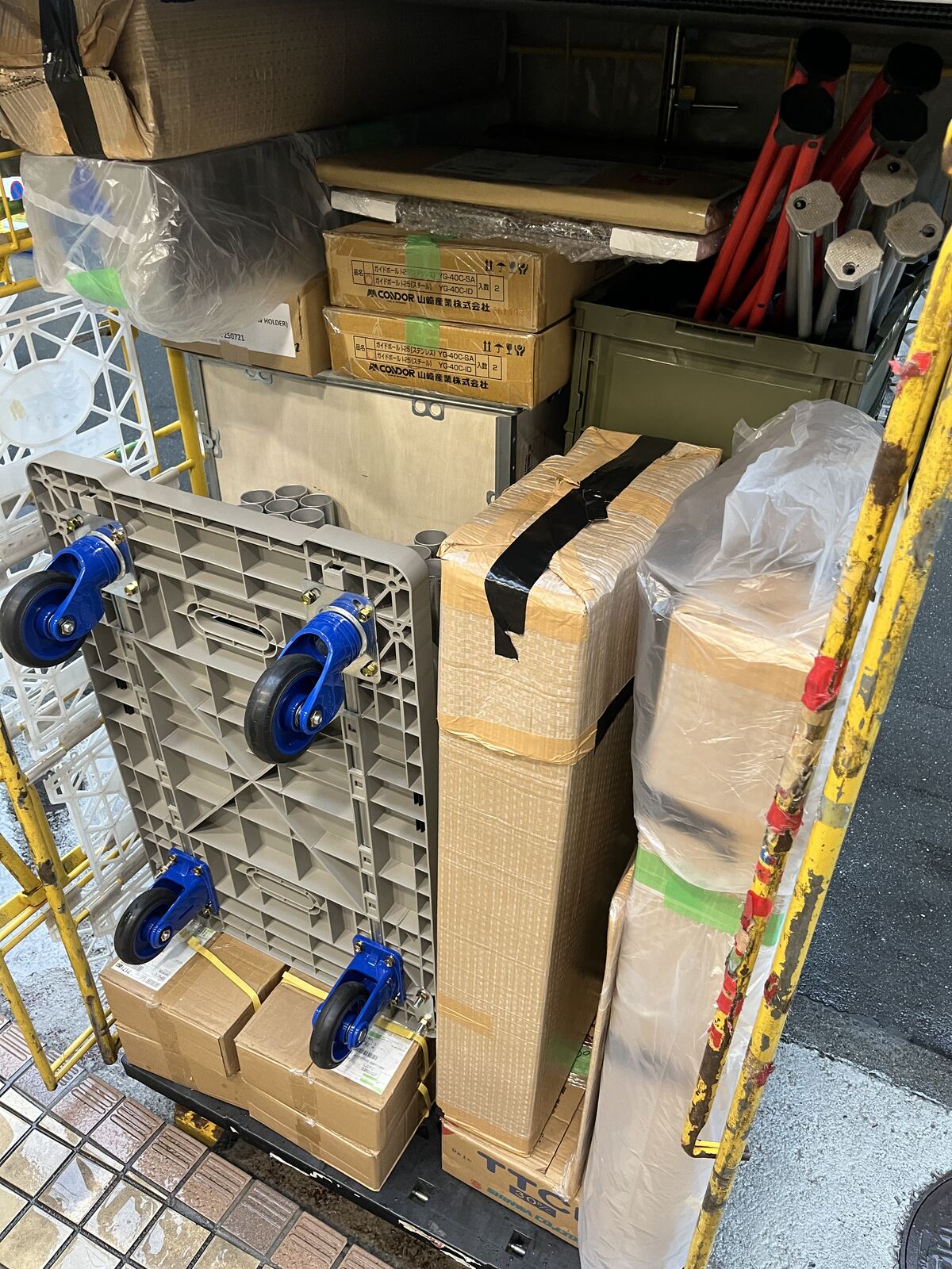 輸送用のかご台車にまとめた梱包済みの部材。