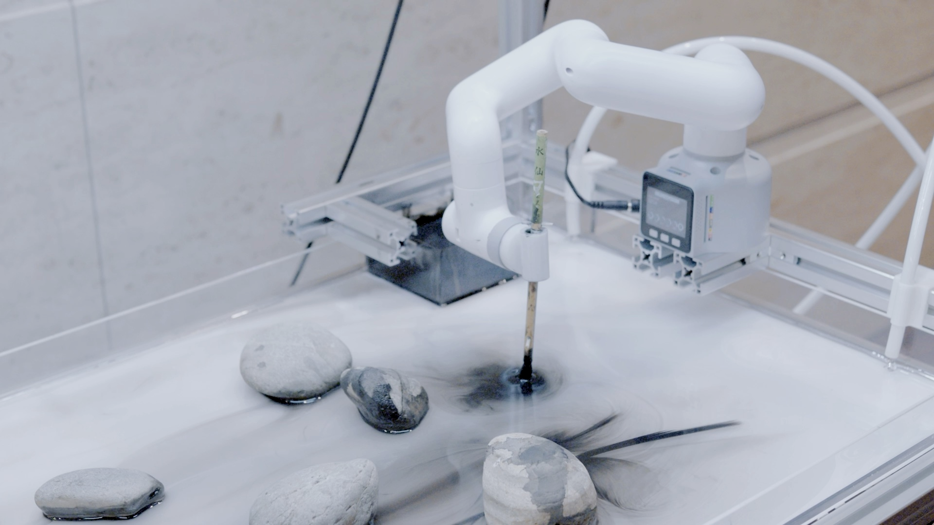 水面に筆を下ろすロボットアーム