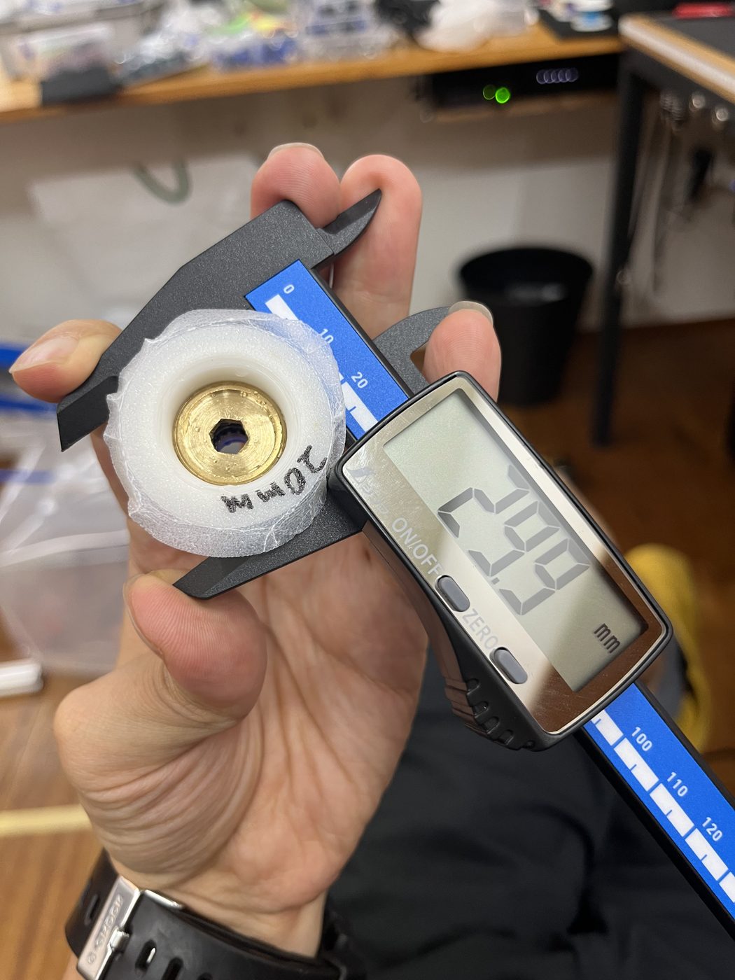 継手の穴の寸法をノギスで測っている様子